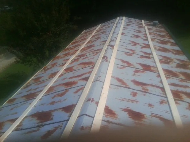 Rusted metal roof panels with new wood purlins before replacement — Storm Damage Roof Repair in Tarrs by Roofing Brothers