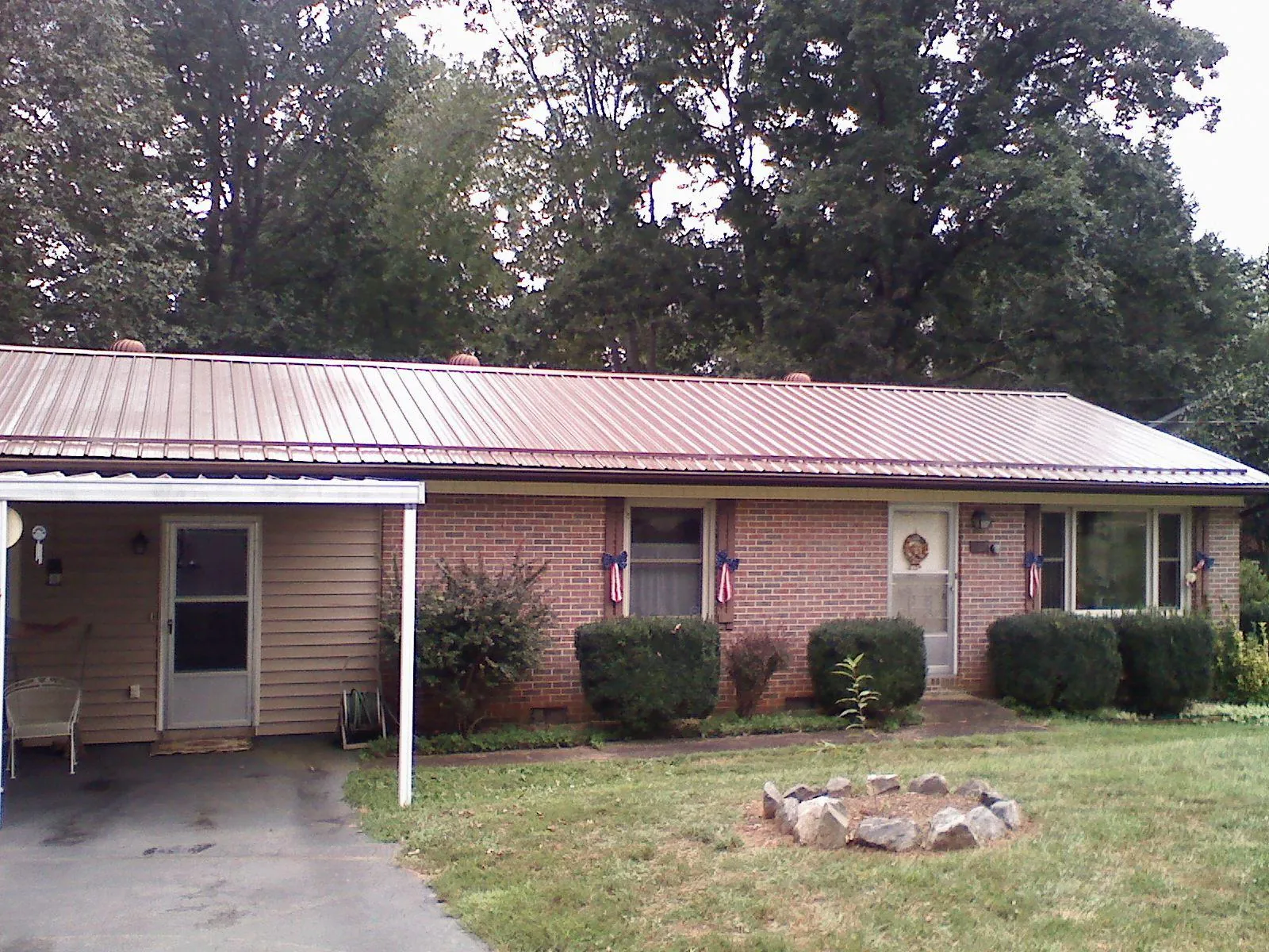 Bronze metal roof and carport on a brick ranch home — Roof Repair work by our crew in Tarrs